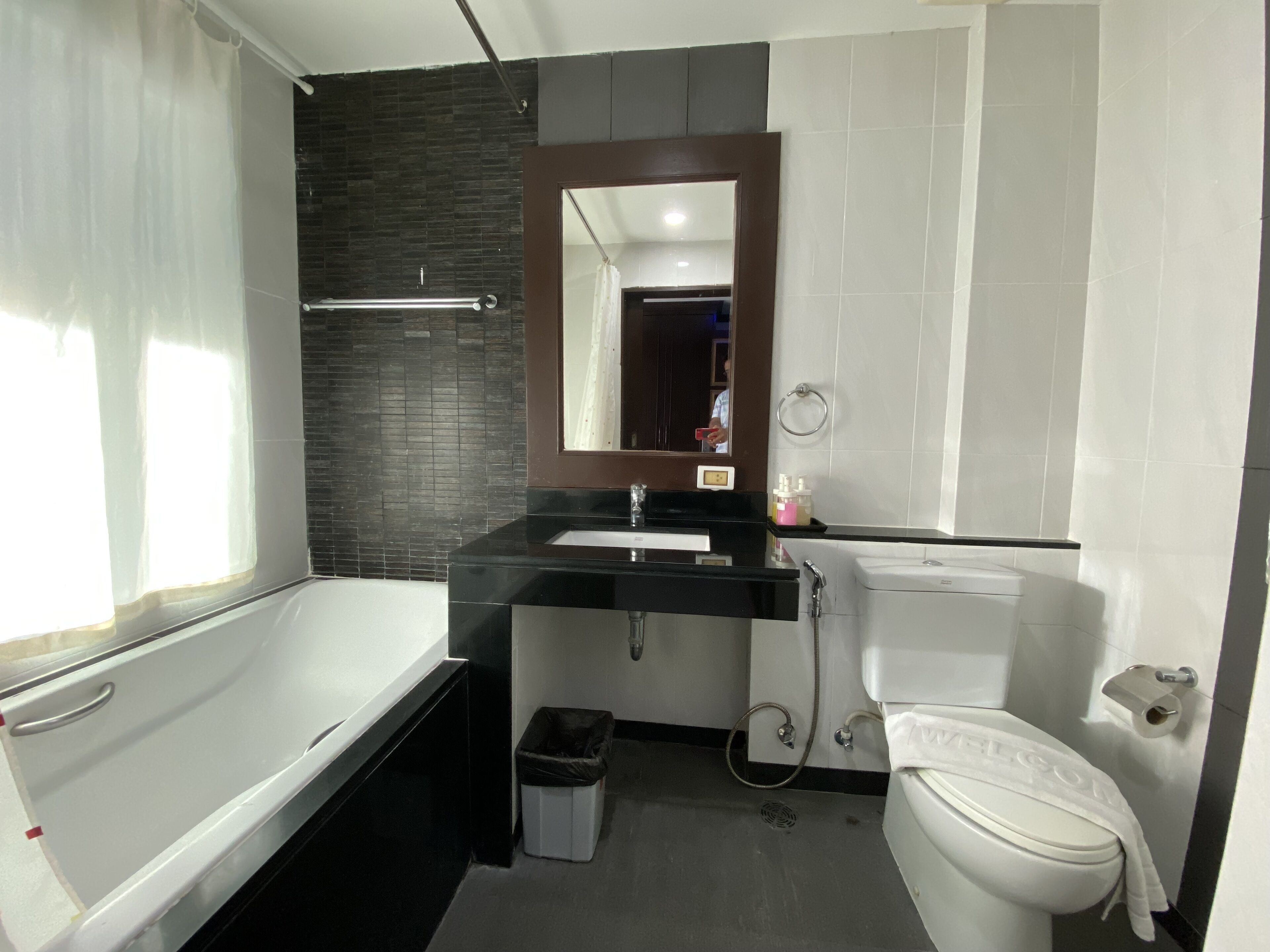 Un baño moderno con lavamanos negro, inodoro blanco y bañera.