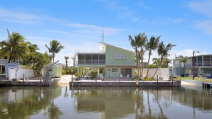 Une propriété située au bord de l’eau, dotée d’un bâtiment écologique, d’un quai et de palmiers.