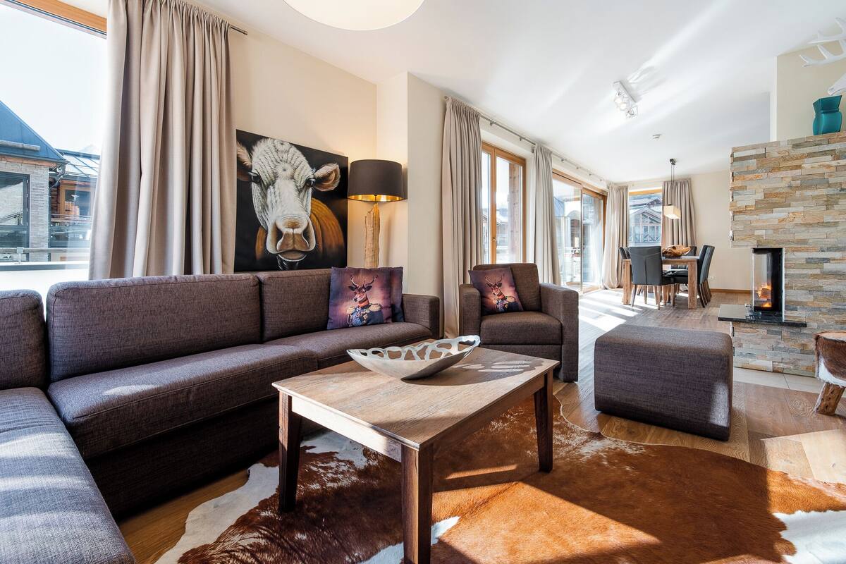 Una sala de estar moderna con un sofá, una mesa de centro y una chimenea.