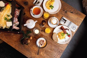 Une table de petit-déjeuner avec divers aliments, une théière et une tasse de thé.