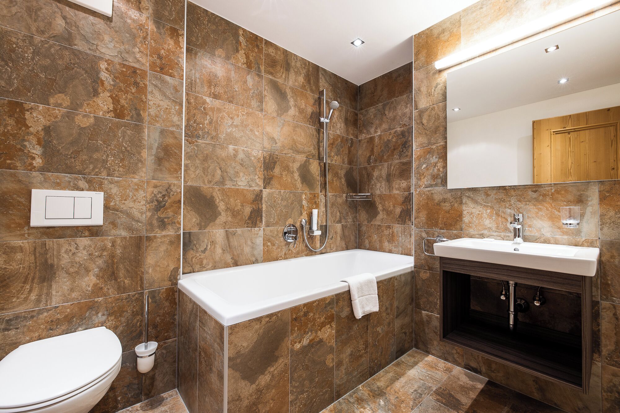 A modern bathroom with a bathtub, a sink, and a toilet.