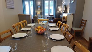 Zona pranzo con tavolo apparecchiato per sei, comprensivo di piatti, bicchieri da vino e un cesto di frutta.