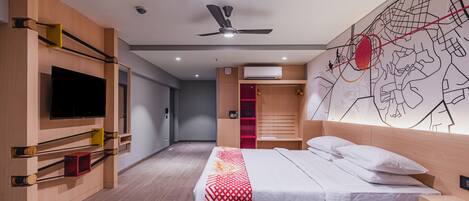 Una habitación de hotel moderna con cama, televisor de pantalla plana, ventilador de techo y un mapa mural.