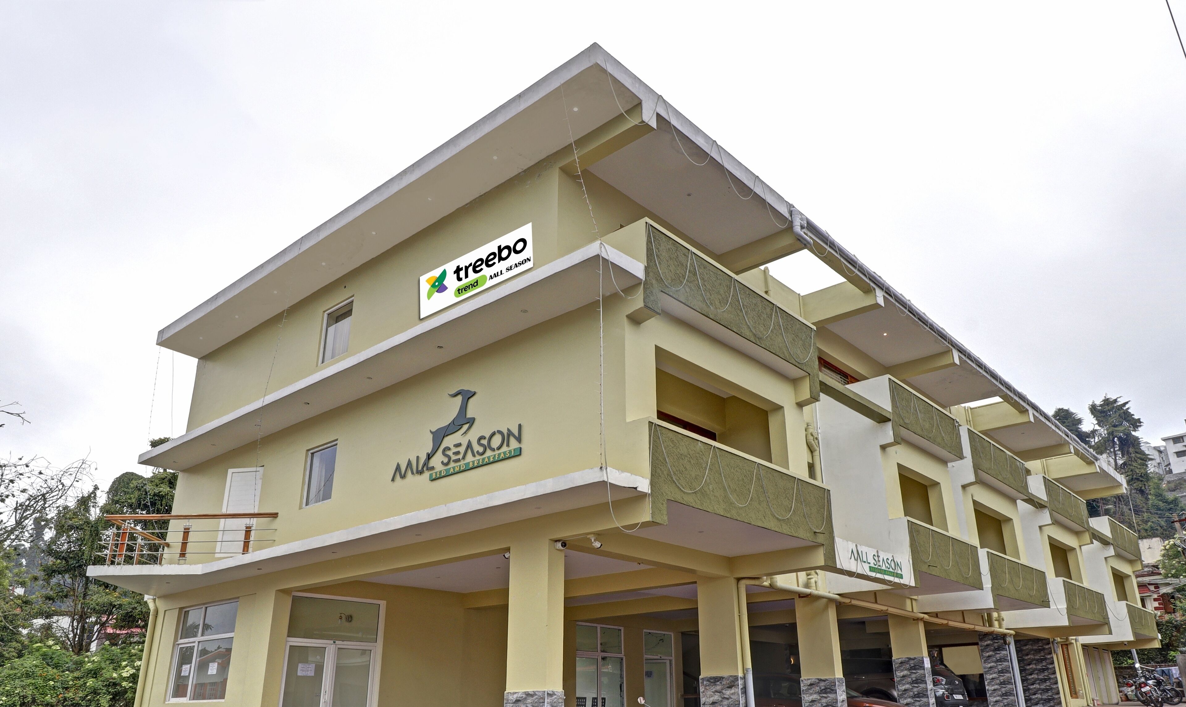 Un hotel de varios pisos con un cartel que dice 'treebo trend' y 'ALL SEASON'.