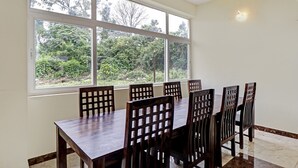 Comedor con un ventanal grande, mesa de madera y sillas.