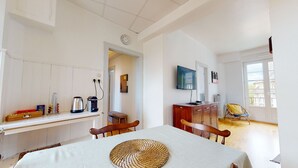 Ein Zimmer mit Esstisch, Stühlen, Fernseher und Fenster mit Blick.