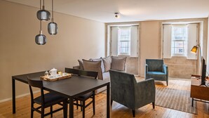 A modern living room with a dining table, chairs, a sofa, and a TV. - Quite One-Bedroom Apart for 3 in Center (Oporto)