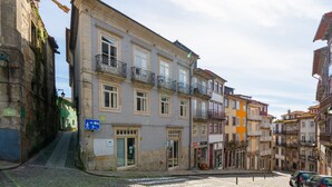 A cobblestone street with historic buildings, a visible entrance, and a sign indicating a pedestrian area. - Quite One-Bedroom Apart for 3 in Center (Oporto)