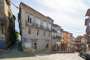 A cobblestone street with historic buildings, a visible entrance, and a sign indicating a pedestrian area.