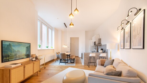 A modern living room with a sofa, a dining area, and a kitchen. - Casita Loft with 80 sqm (air-conditioned), with good transport connections (Ludwigshafen am Rhein)