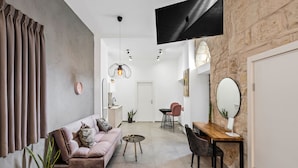 A modern living room with a sofa, coffee table, and dining area.