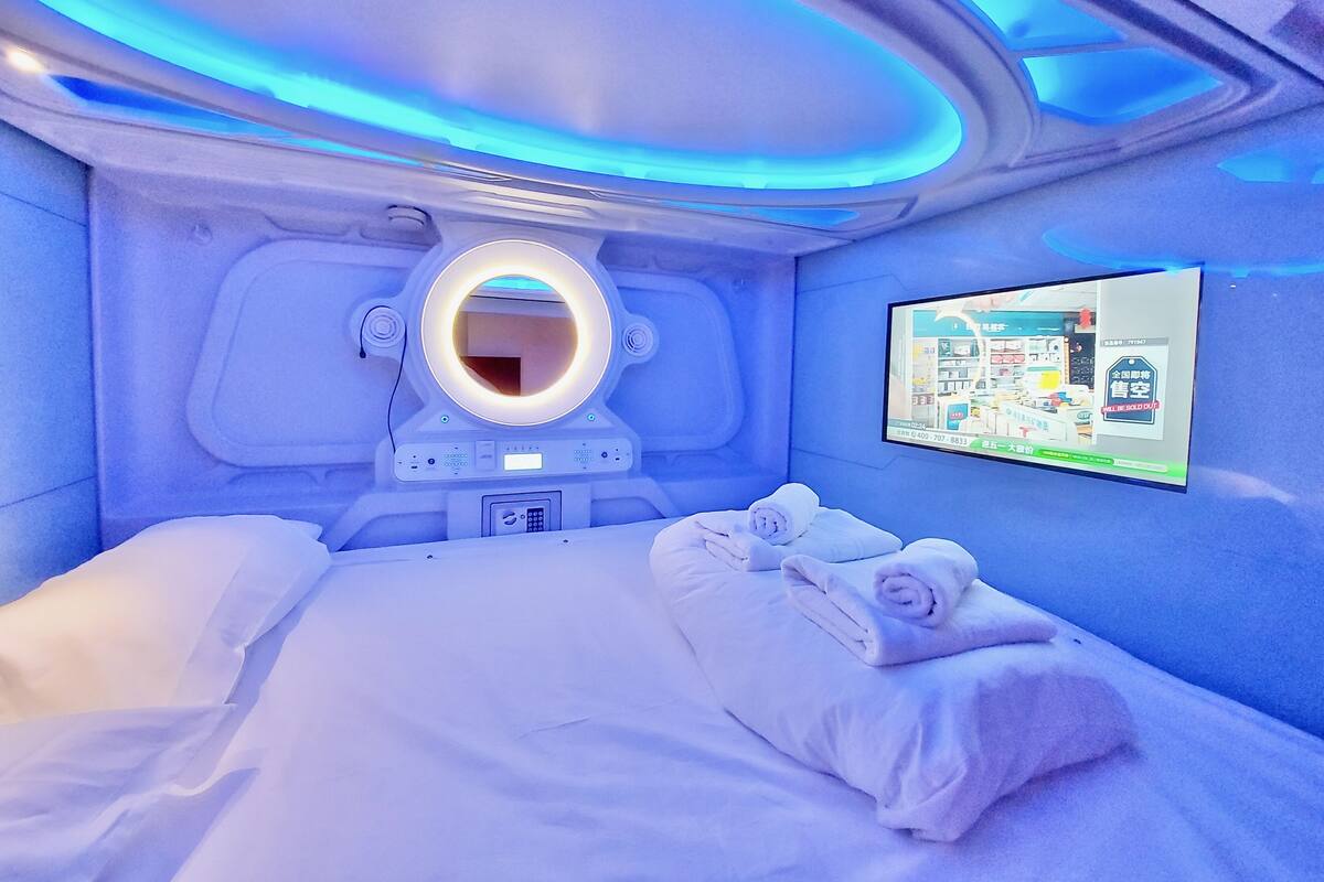 A room with a bed, a toilet, and a TV screen displaying a map.