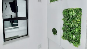 A modern interior with multiple windows and green wall installations. - Atypicap Capsule Hostel (Puerto de la Cruz)