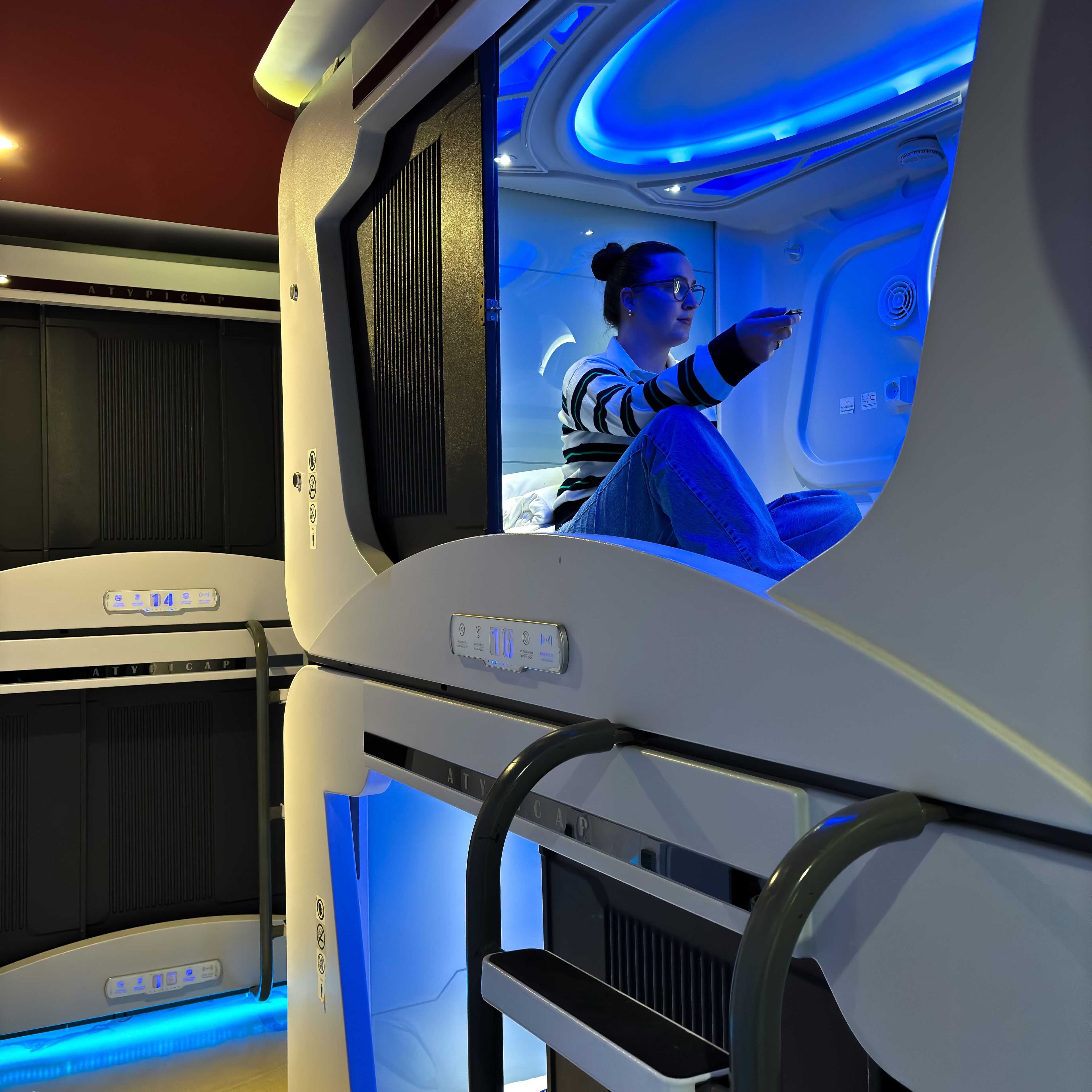 A modern, well-lit room with a large window, a control panel, and a seating area.
