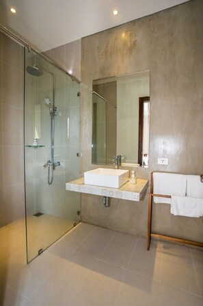 A modern bathroom with a glass-enclosed shower, a vanity with a mirror, and a towel rack. - Mad Monkey Hoi An (Da Nang)