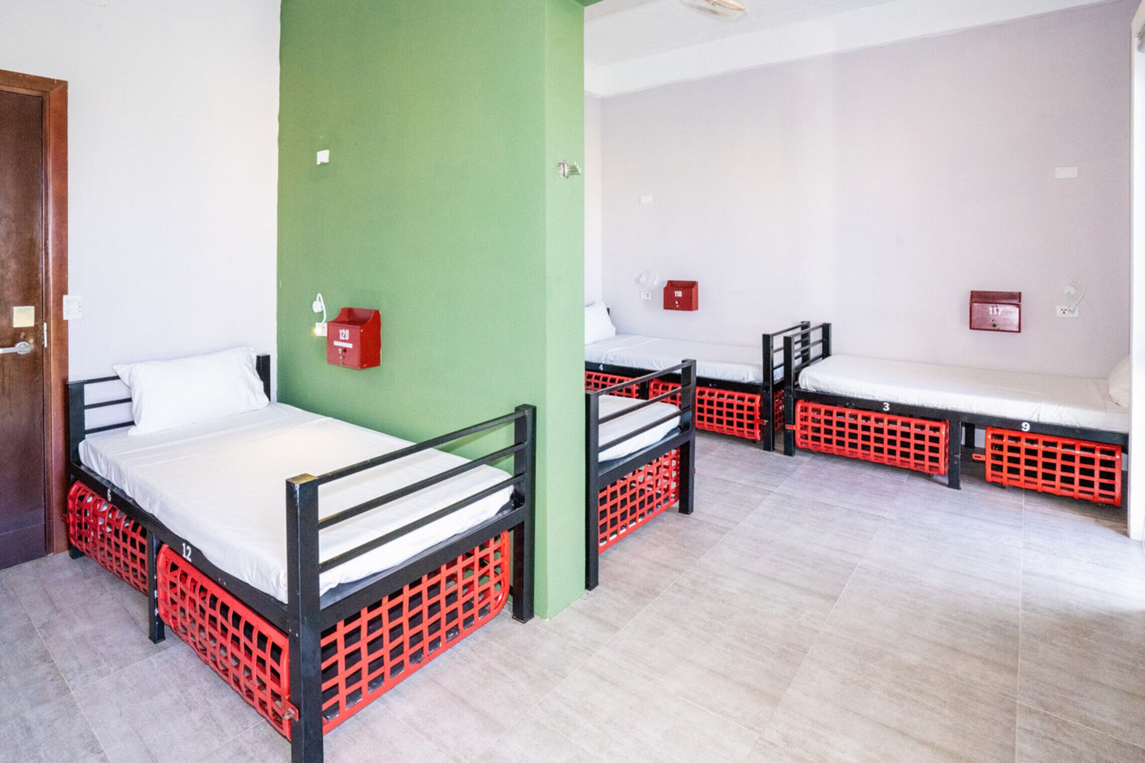 Habitació amb lliteres, una paret verda i un sostre blanc.