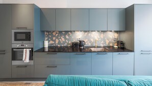 Una cocina compacta con armarios grises, microondas y cafetera.
