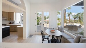 Eine geräumige Küche mit moderner Kücheneinrichtung und einem großen Fenster mit Blick auf eine Terrasse.