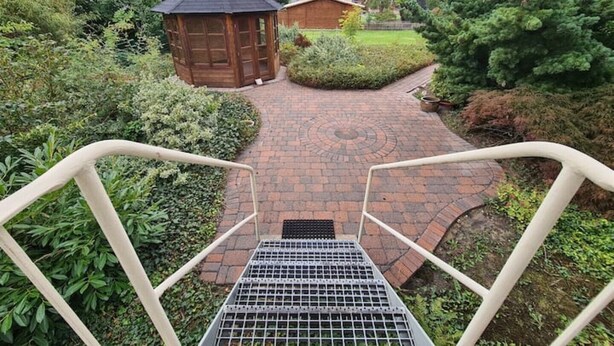 A brick pathway leading to a wooden gazebo surrounded by greenery. - 4-room vacation apartment - renovated - WLAN - Netflix (Castrop-Rauxel)