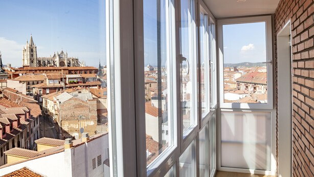 A balcony with a view of a historic cathedral and surrounding cityscape.