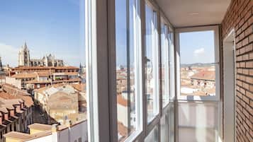 Un balcón con vistas a una catedral histórica y al paisaje urbano circundante.