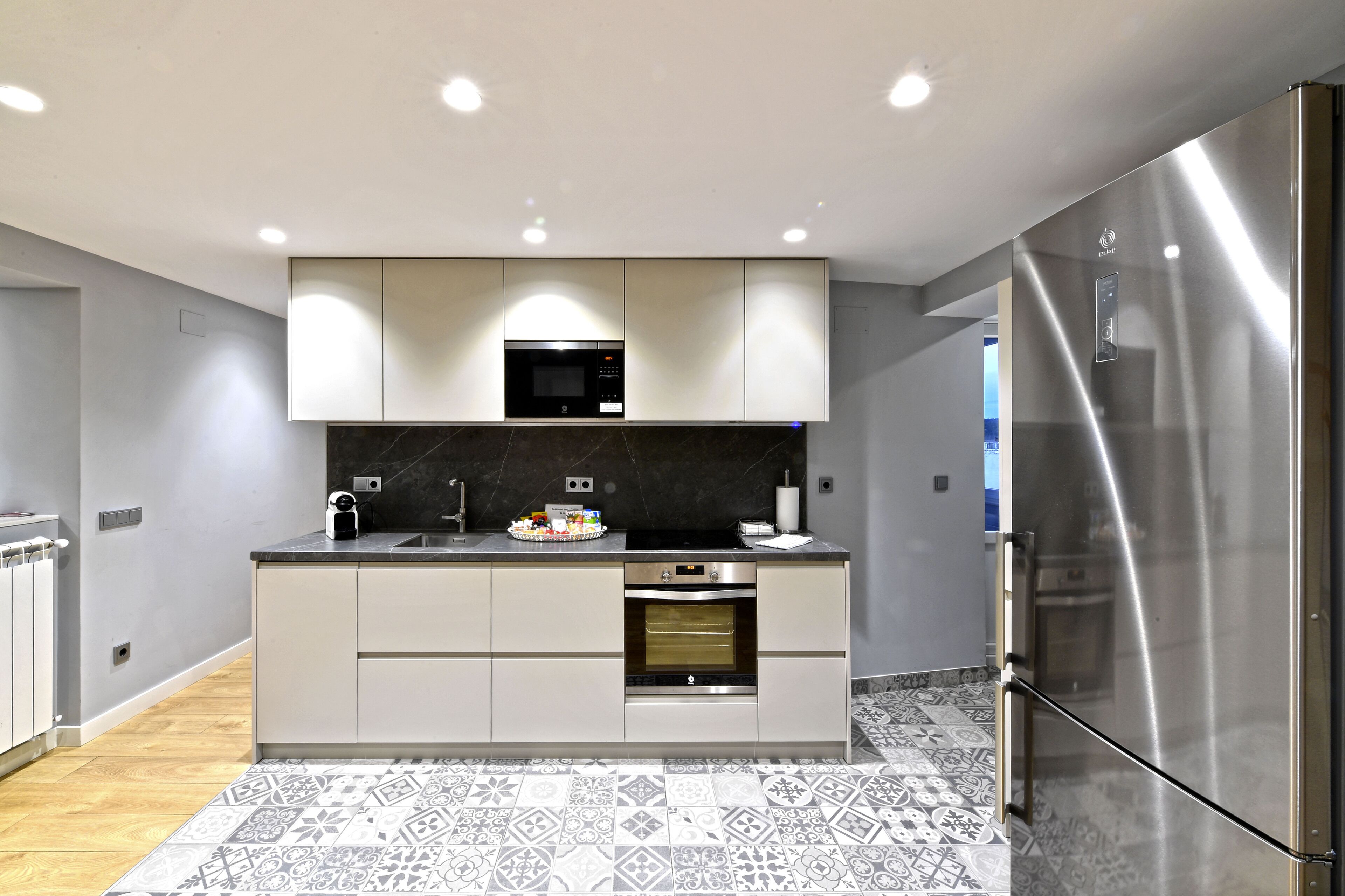 Una cocina moderna con microondas, horno y refrigerador incorporados.