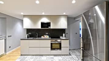 Una cocina moderna con microondas, horno y refrigerador incorporados.