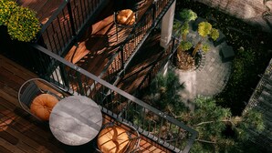 A multi-level outdoor terrace with wooden flooring, metal railings, and various seating arrangements including round tables and chairs. - WELTWIEN Apartments (Vienna)