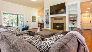 A spacious living room with a fireplace, built-in shelves, and a dining area. - Spacious Mt. Bachelor Retreat w/ Hot Tub + Pets OK (Bend)