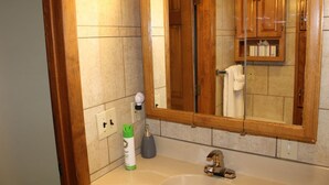 A bathroom with a wooden vanity, a large mirror, a sink, and a towel rack. - Cooperstown Baseball Rentals - Team Basemen (Oneonta)