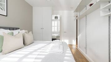 Una camera da letto con un letto, cuscini, un comodino e un armadio.