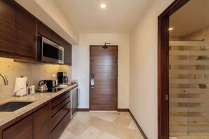 A modern kitchen with a microwave, coffee maker, and sink.