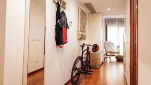 A hallway with a bicycle, a 'WELCOME' sign, and a chair in a room with a window. - 2 bedroom apartment RM7 (Girona)