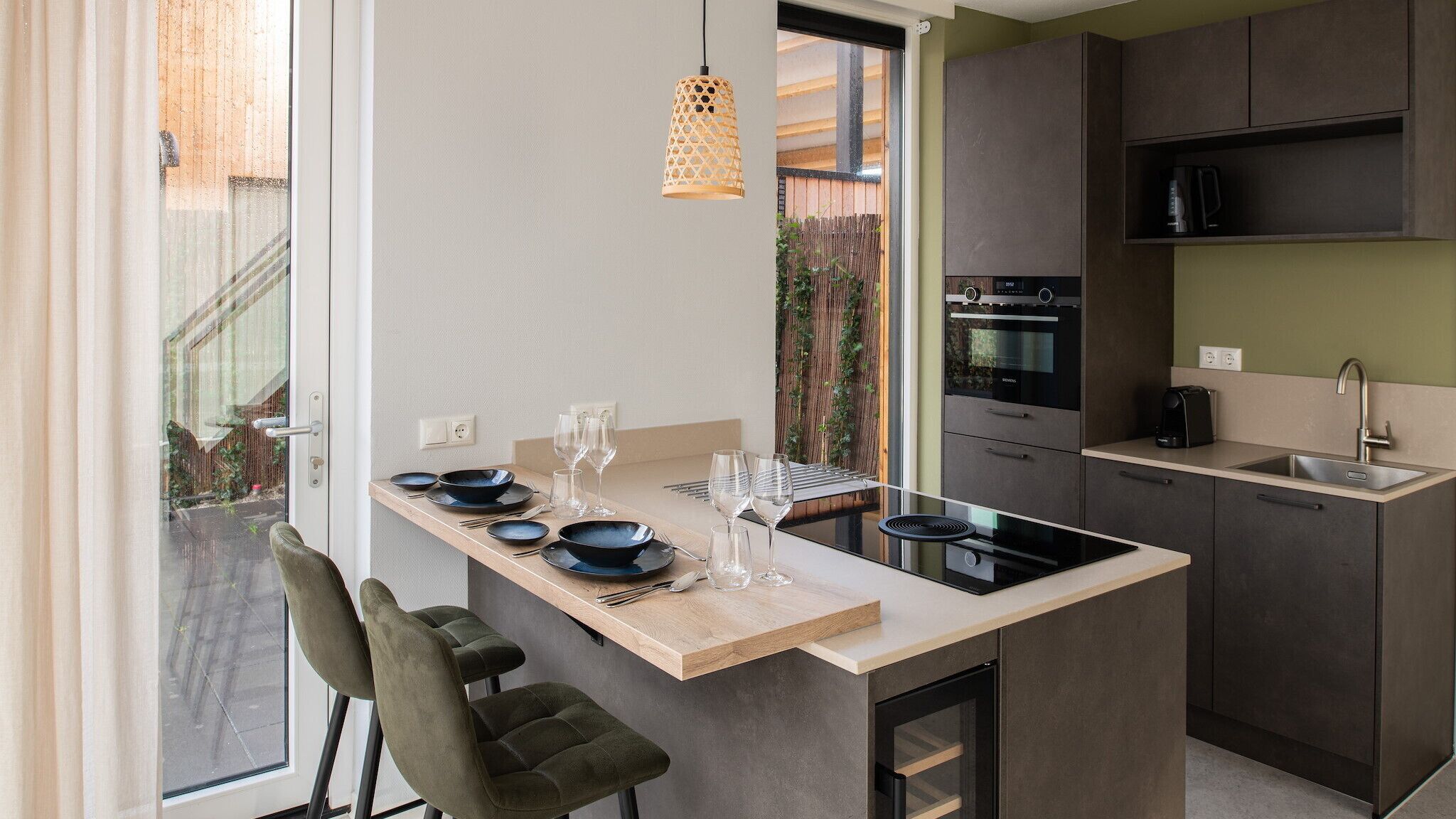 A modern kitchen with a central island, built-in oven, and a sink.