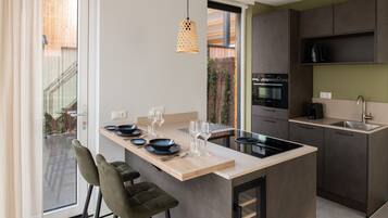 A modern kitchen with a central island, built-in oven, and a sink.