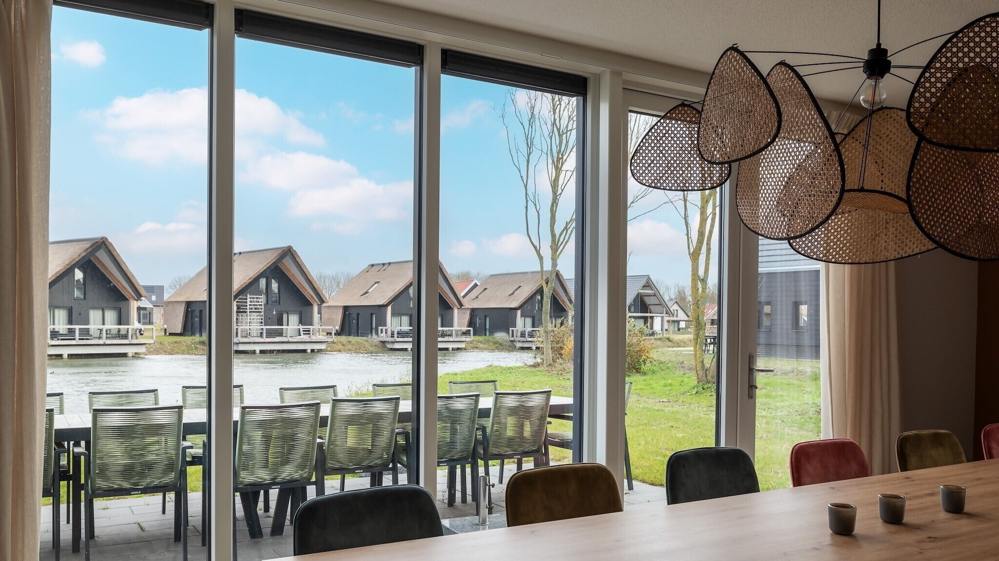 A dining area with a view of a water body and houses.