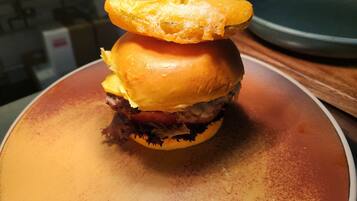 A burger with a toothpick on top, placed on a plate.