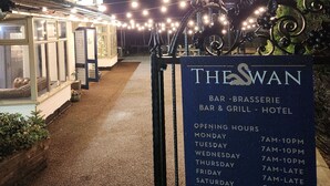 A sign for The Swan Bar-Brasserie Bar & Grill - Hotel with opening hours listed for each day of the week. - The Swan - A Colombo Edition Hotel (Ely)