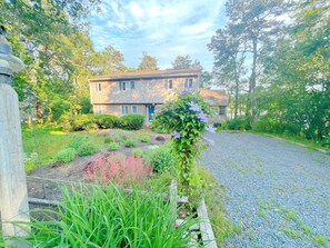 Traditional home surrounded by a beautifully maintained garden and lush green surroundings.