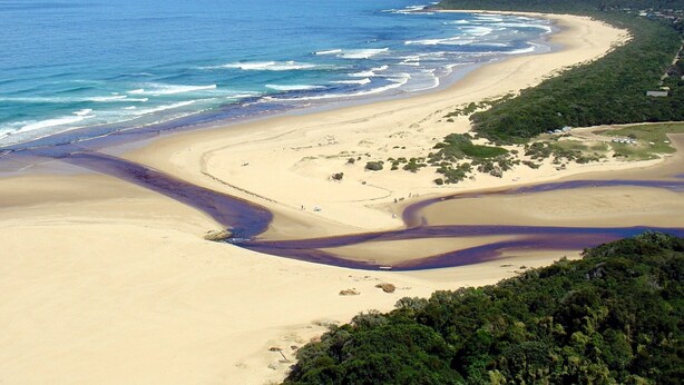 A coastal landscape with a sandy beach, a winding water channel, and a forested hill. - Sea Why is a self-catering apartment in Nature's Valley , 5 min from the beach (Plettenberg Bay)
