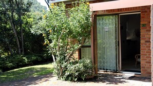 A brick building with a green door and a sign that reads "Sea Why." - Sea Why is a self-catering apartment in Nature's Valley , 5 min from the beach (Plettenberg Bay)