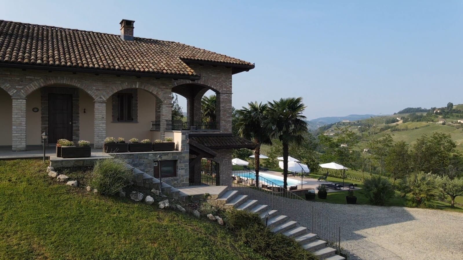 Une villa en pierre dotée d’une piscine, d’un espace extérieur aménagé et offrant une vue sur la campagne.