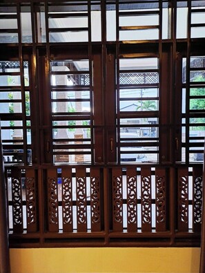 Traditional entrance with intricate lattice patterns and a glimpse of the surrounding area.