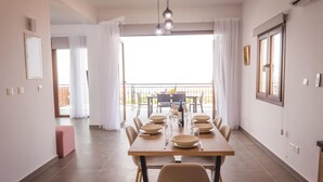 Zona pranzo con tavolo apparecchiato per sei, un balcone con vista e un design d'interni moderno.