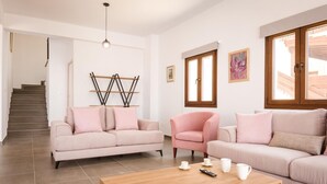 Un soggiorno con una scala, due divani, un tavolino da caffè e opere d'arte alle pareti.