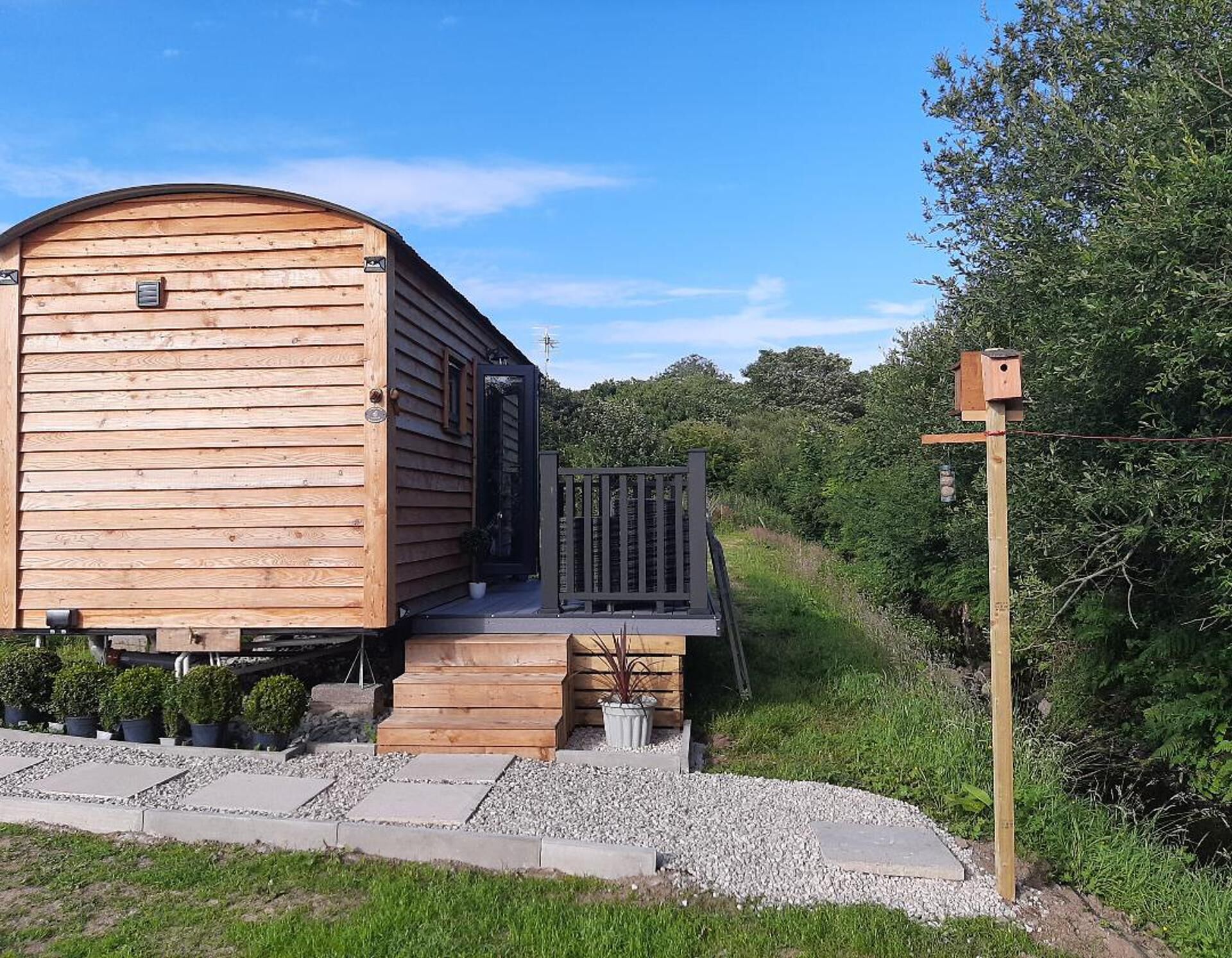Eine Holzhütte mit Veranda und einem kleinen Garten.