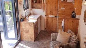 A cozy room with a wooden cabinet, a sink, and a striped sofa.