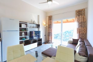 Relax in this stylish living room with a flat-screen TV, glass coffee table, and comfortable sofa.