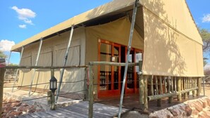 A safari tent with a wooden deck and stone walls. - Tsabong Eco-Tourism Camel Park (Tshabong)