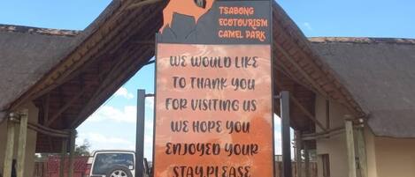 Un cartel en el Parque Ecoturístico de Camellos de Tsabong con un mensaje agradeciendo a los visitantes e invitándolos a regresar.